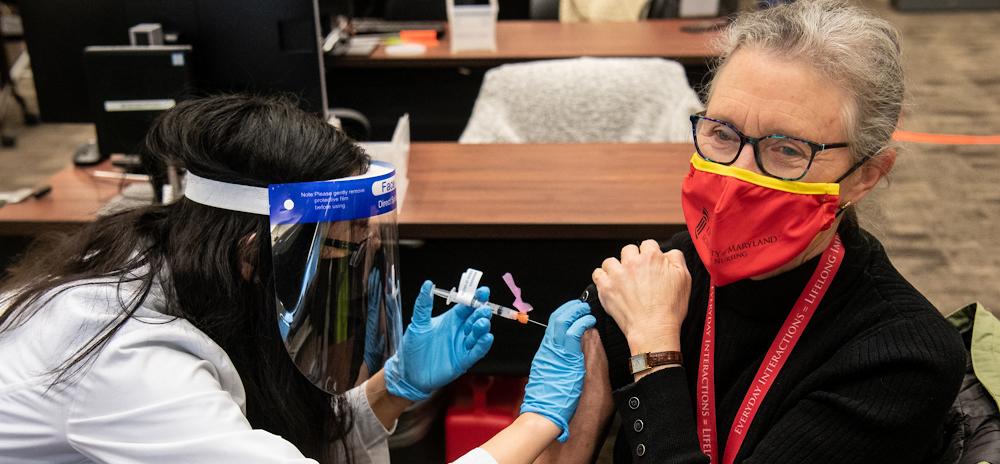 School of Nursing Dean Jane M. Kirschling receives her first dose of the Moderna COVID-19 vaccine from School of Pharmacy student Amy Chen at the SMC Campus Center.