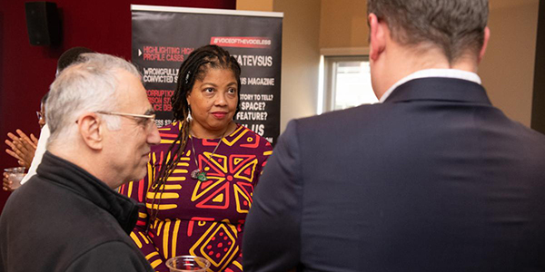 Nadine Finigan-Carr, speaks with Thomas Scalea and another attendee at the Peace Is a Civil Right” open house