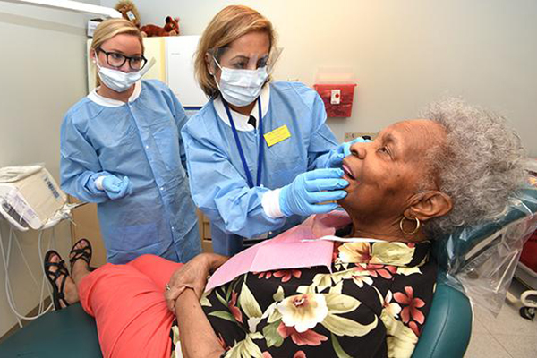 Dentists treat an elderly woman