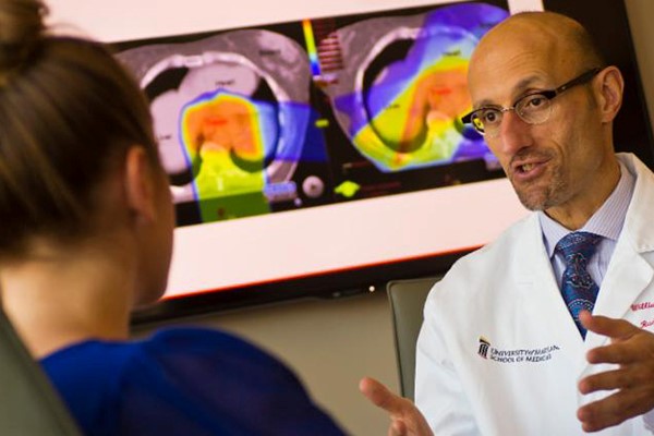 A man wearing a lab coat demonstrates the GammaPod