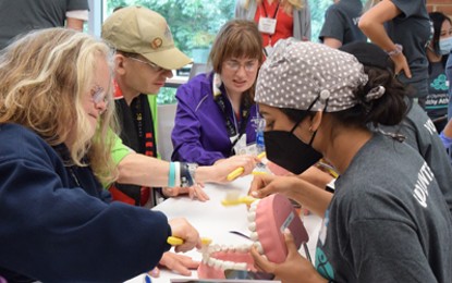 University of Maryland School of Dentistry student volunteers demonstrate proper brushing techniques to Special Olympics athletes.