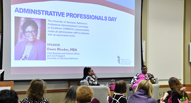 two women discussing questions after Dawn Rhodes presentation