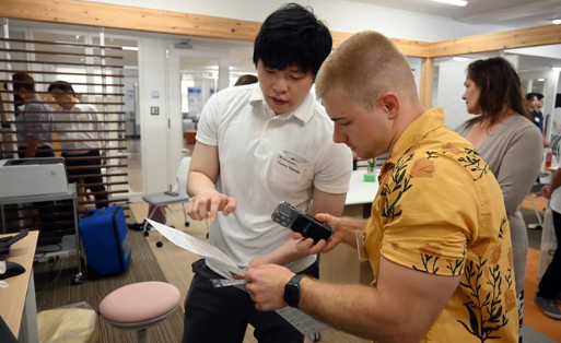 A UMB and Japanese student examine a medical device