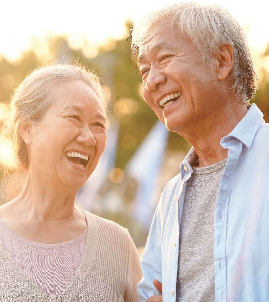 Two senior Japanese people laugh outside