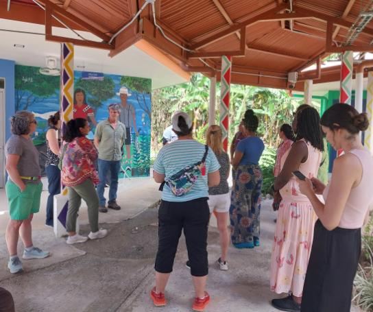 A group of people listen to a speaker outside in Costa Rica