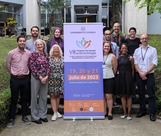 UMB faculty pose for a photo with a banner in Costa Rica