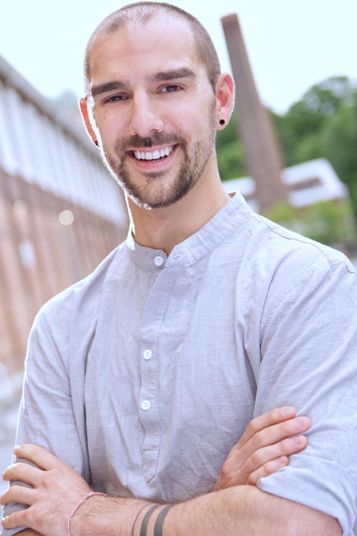 Headshot of a man outside with crossed arms