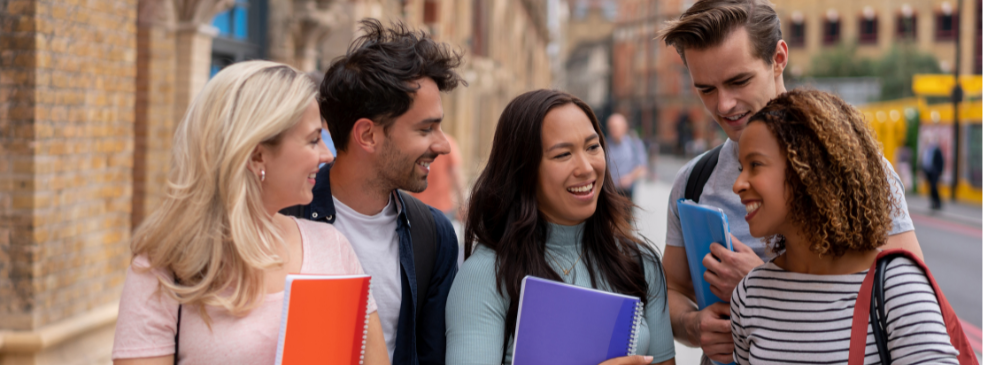 Five students huddle together to talk