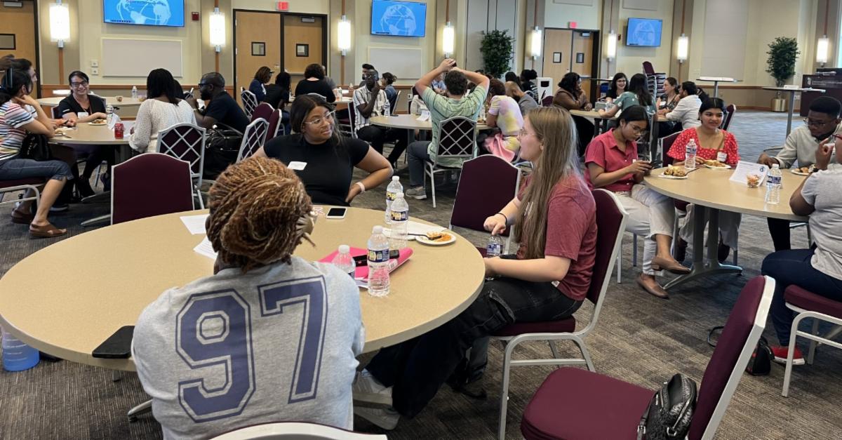 Students sit at tables at an event