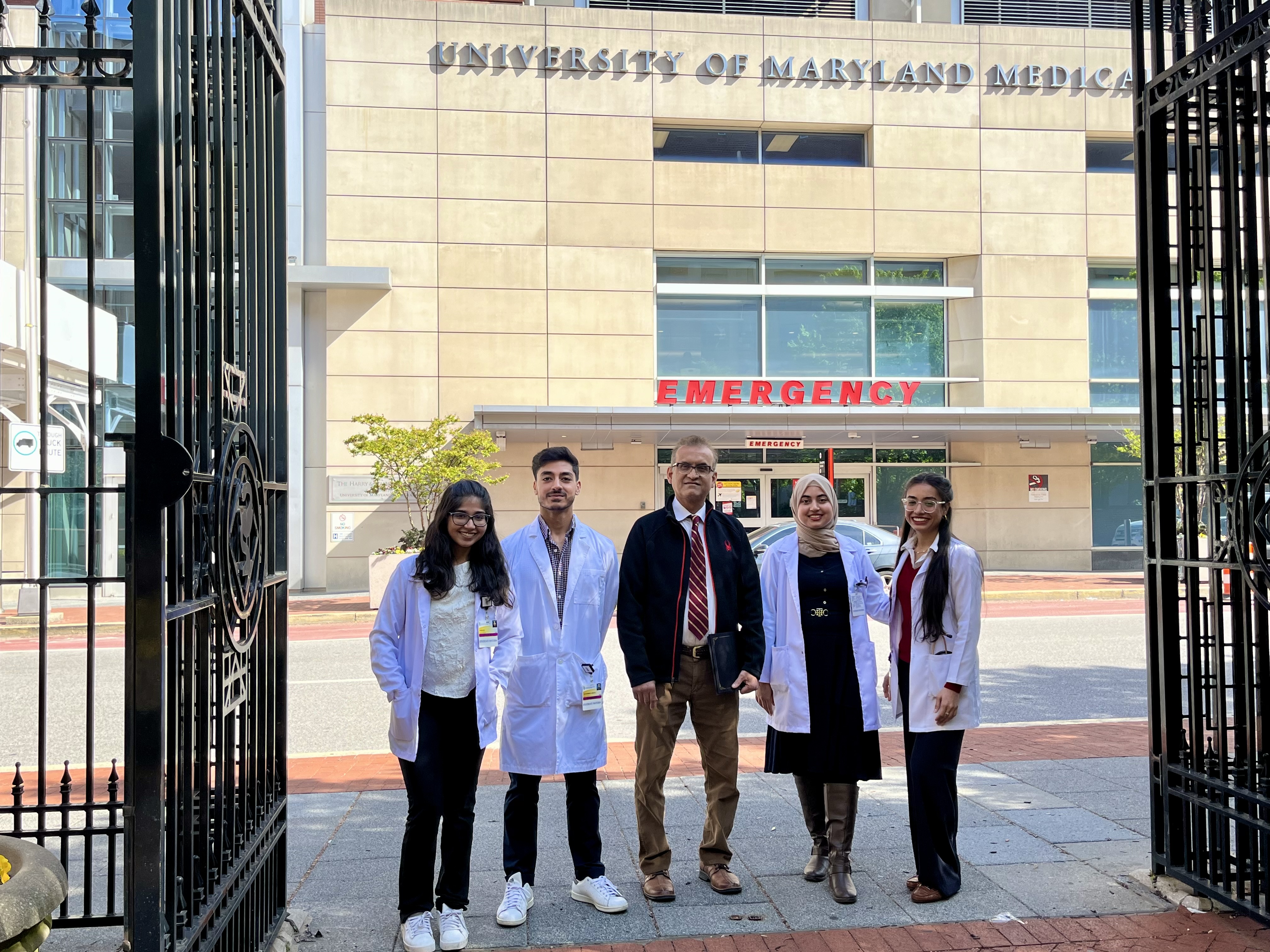 Four students and a doctor from Pakistan pose for a photo outside Shock Trauma