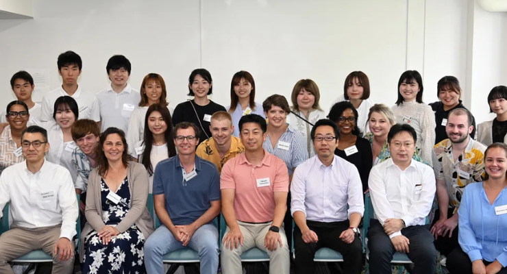 Students and faculty pose for a group photo inside an office