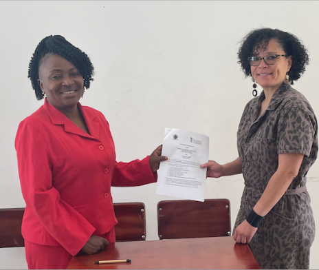 Two women hold a document between them