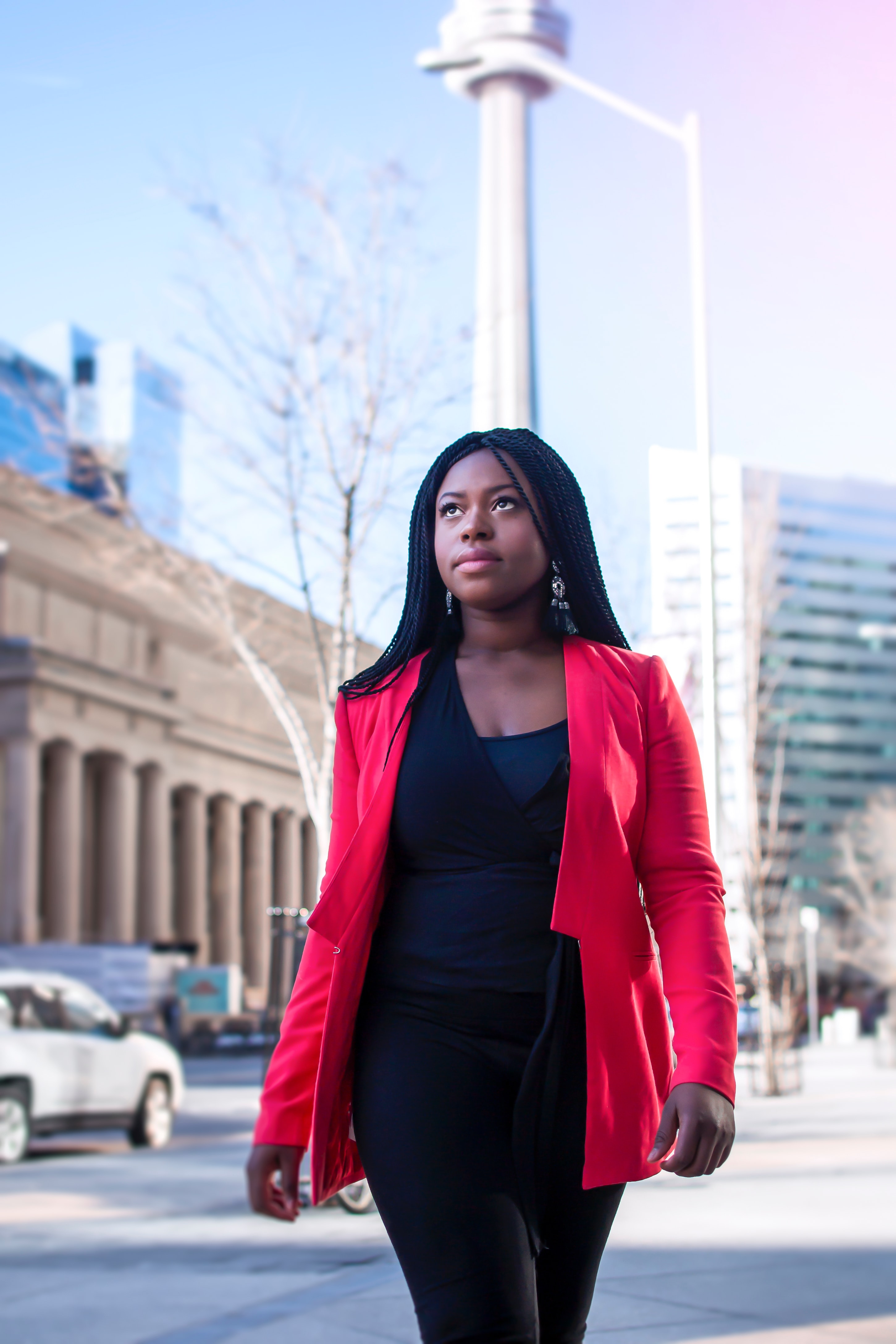 Woman in a red suit walks in a city