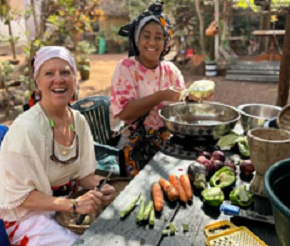 Two women sit outside at a table in Tanzania