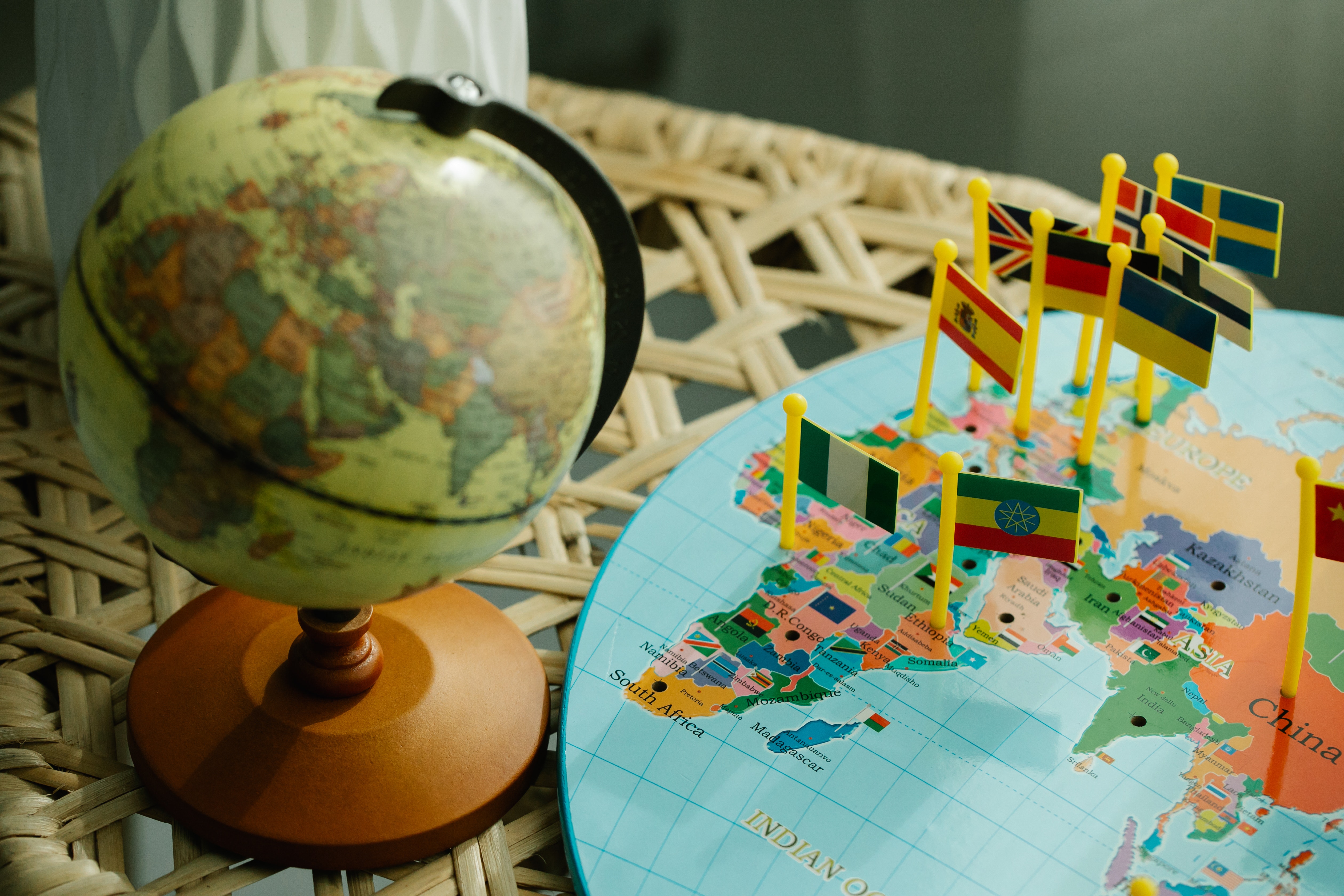 A globe with a map next to it with country flags standing on the map