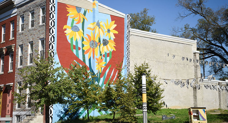 A large mural of sunflowers on the side of a building in Franklin Square