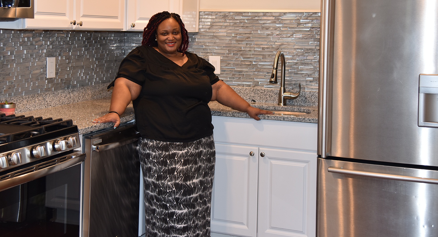 UMB employee Tara Wells poses outside of her newly purchased home in Pigtown