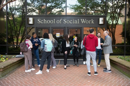 Students and faculty gather outside of the entrance to the University of Maryland School of Social Work.