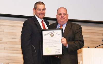 Gov. Larry Hogan, right, presents a governor's citation to the laboratory to Prof. Aaron P. Rapoport, MD, the Gary Jobson Professor in Medical Oncology at the School of Medicine and director of the Blood and Marrow Transplant Program and co-leader of the Tumor Immunology & Immunotherapy Research Program at the UM Marlene and Stewart Greenebaum Comprehensive Cancer Center.