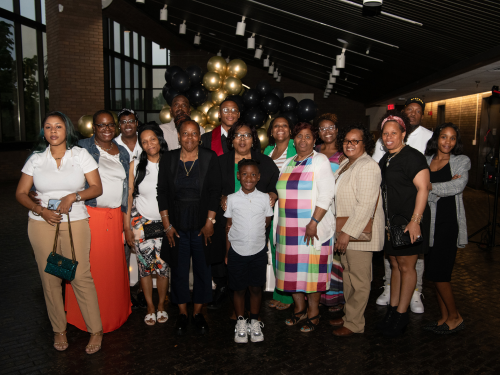 Demonyae Smith (center rear) stands proudly with his family at the CURE Scholars Cohort 3 graduation reception, celebrating a significant milestone in his academic journey.