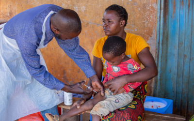 In Malawi, a mother's embrace comforts her child receiving a vaccine.