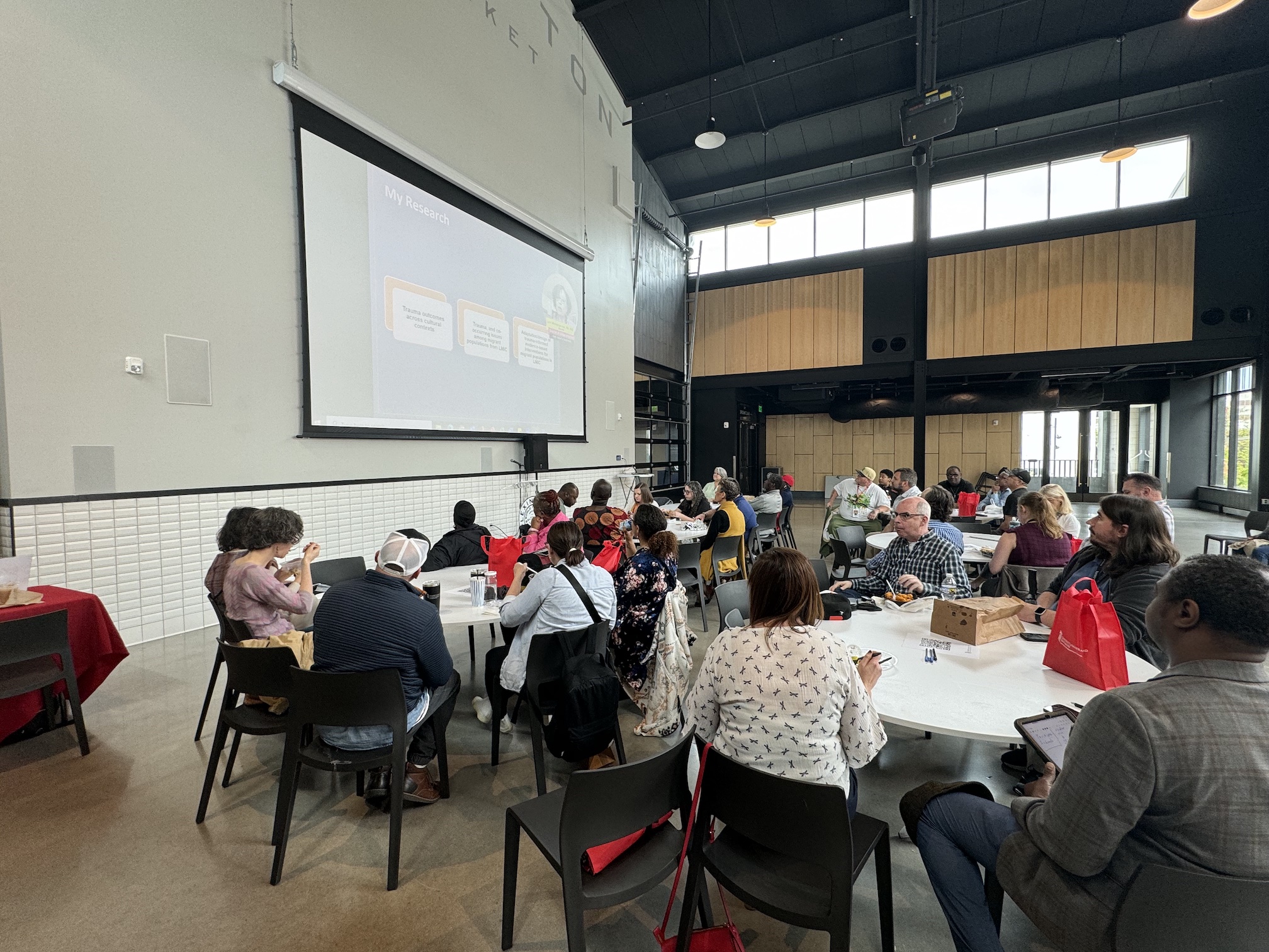 Attendees of the Lexington Market Day event enjoy a meal while engaging with an insightful presentation.