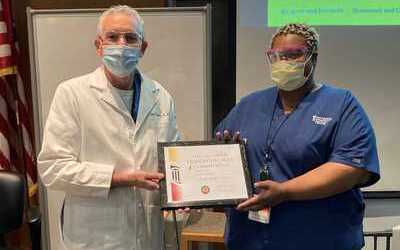 Bert O’Malley, MD, the president and chief executive officer of the University of Maryland Medical Center presents Telisha McDonald with a plaque naming her Employee of the Quarter.