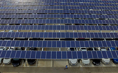 Cars parked under solar photovoltaic systems.