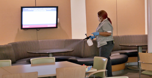 UMB Environmental Services technician Sierra Tyler applies a new EPA-registered disinfectant chemical using a pump spray bottle inside Pharmacy Hall. This spray has a 10-minute dwell time and is used for surface cleaning for COVID-19. 