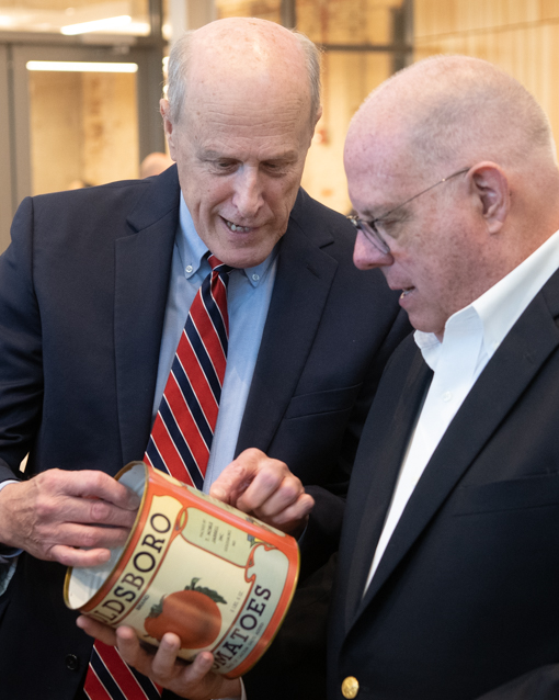 University of Maryland, Baltimore President Bruce E. Jarrell shows a tomato can from his family's Eastern Shore business to Gov. Larry Hogan.