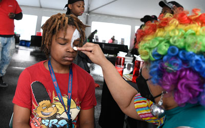 Sparkles the Clown sets up a face painting booth at UMB's annual Neighborhood Spring Festival. 