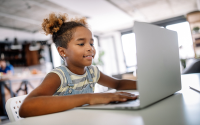 A student working a a laptop. Stock image.