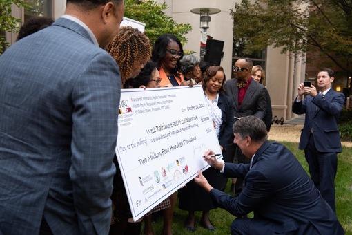 Sen. Guy Guzzone, chair of the Budget and Taxation Committee, signs the ceremonial grant check.