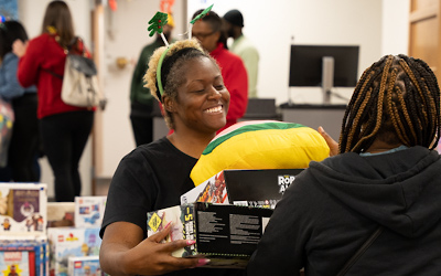 West Baltimore neighbors browse the toy selection at the annual Christmas Store, set up in UMB's Community Engagement Center.