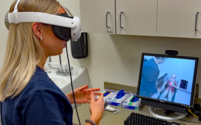 A student wearing VR goggles participates in a virtual exam.