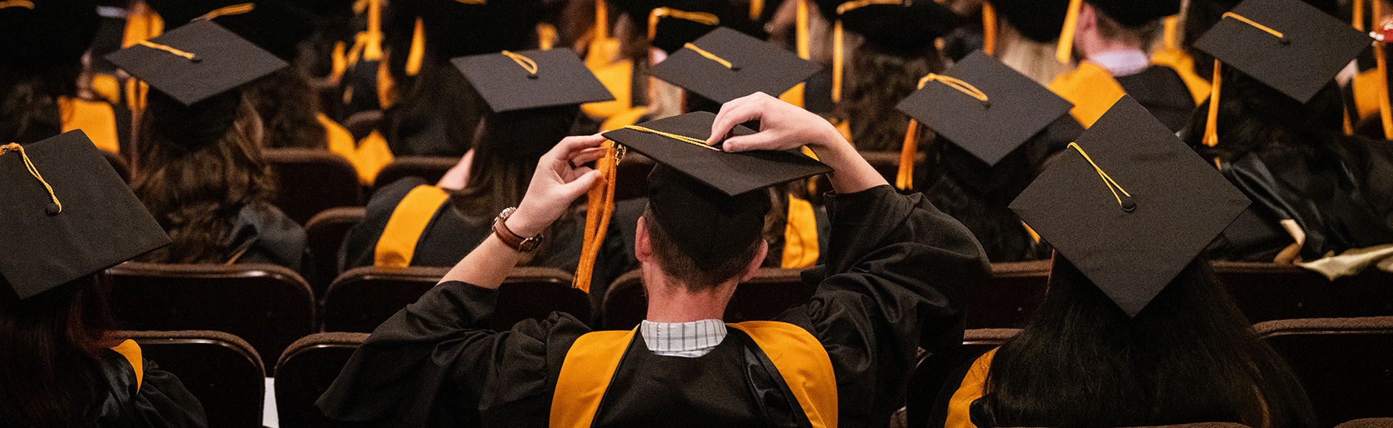 A student fixing his graduation cap