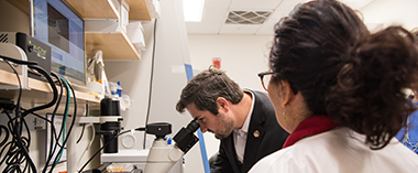 A man looking into a microscope