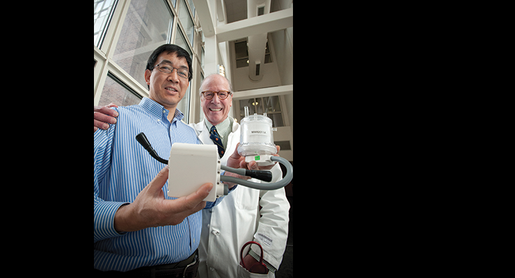 Two men holding a device