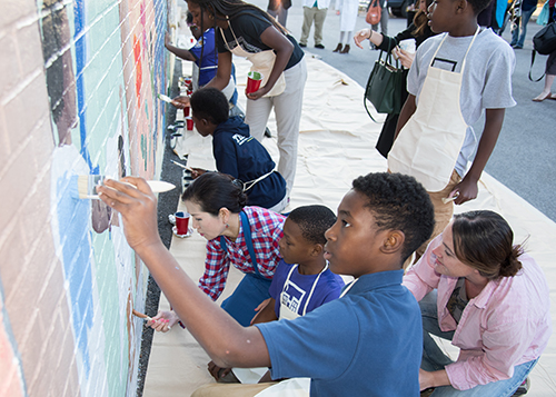 Yumi Hogan and Kids painting a mural