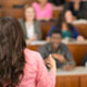 faculty member lecturing in front of blurred classroom