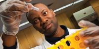 Image of a Scientist holding up a test tube.